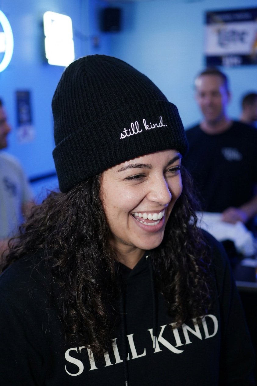 Black cuffed beanie with still kind script embroidery