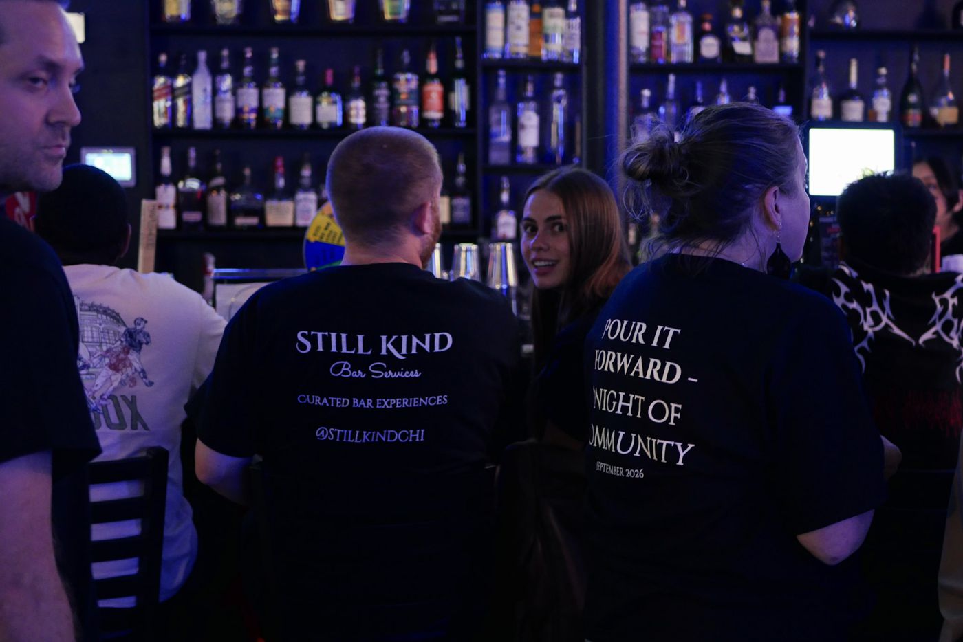 Guests at the bar in Pour It Forward shirts